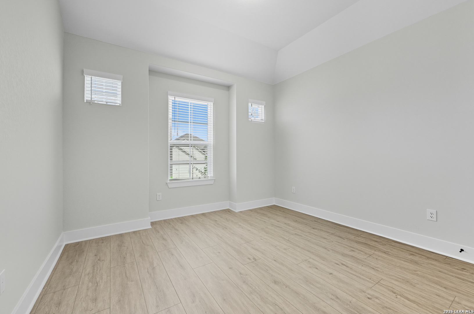 210 Kari Drive Castroville, TX 78009 - Photo 22 of 29 an empty room with wooden floor and windows
