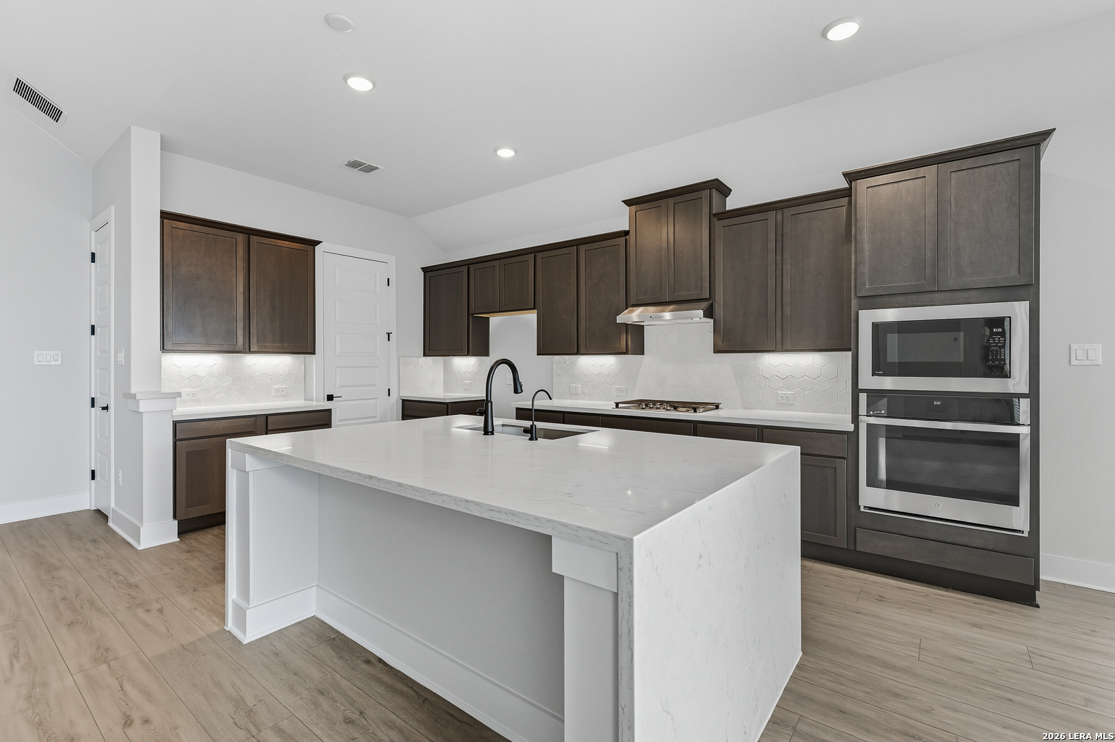 210 Kari Drive Castroville, TX 78009 - Photo 3 of 29 a kitchen with kitchen island a sink stainless steel appliances and cabinets