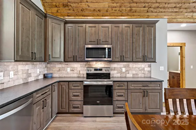 a kitchen with a table chairs refrigerator and cabinets