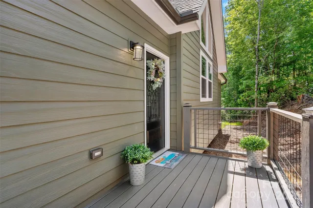 a view of a house with a wooden deck and a yard