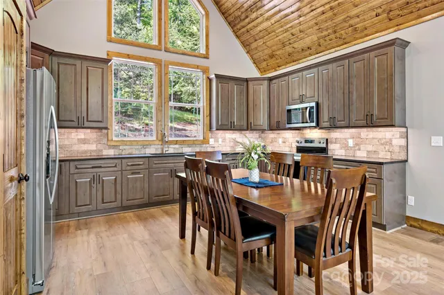 a kitchen with stainless steel appliances granite countertop a chairs and a refrigerator