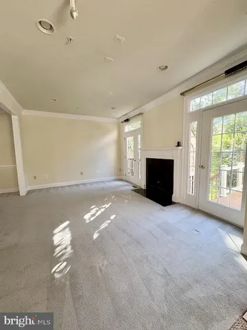 a view of an empty room with a fireplace and a window