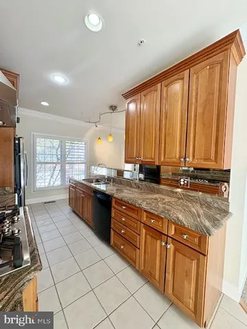 a kitchen with granite countertop a refrigerator and a sink
