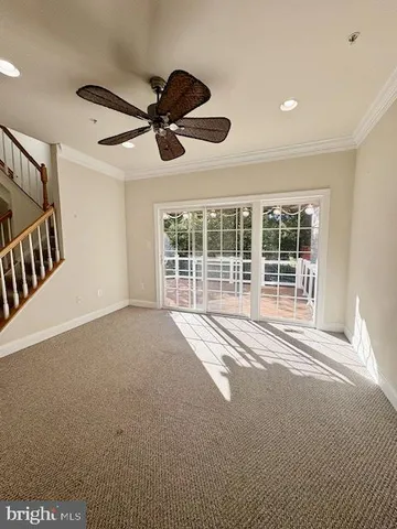 a view of an empty room with a ceiling fan and window