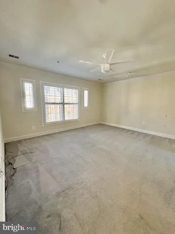 an empty room with windows and fan