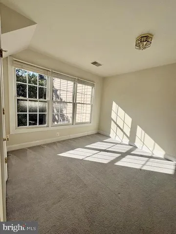 an empty room with a ceiling fan and window