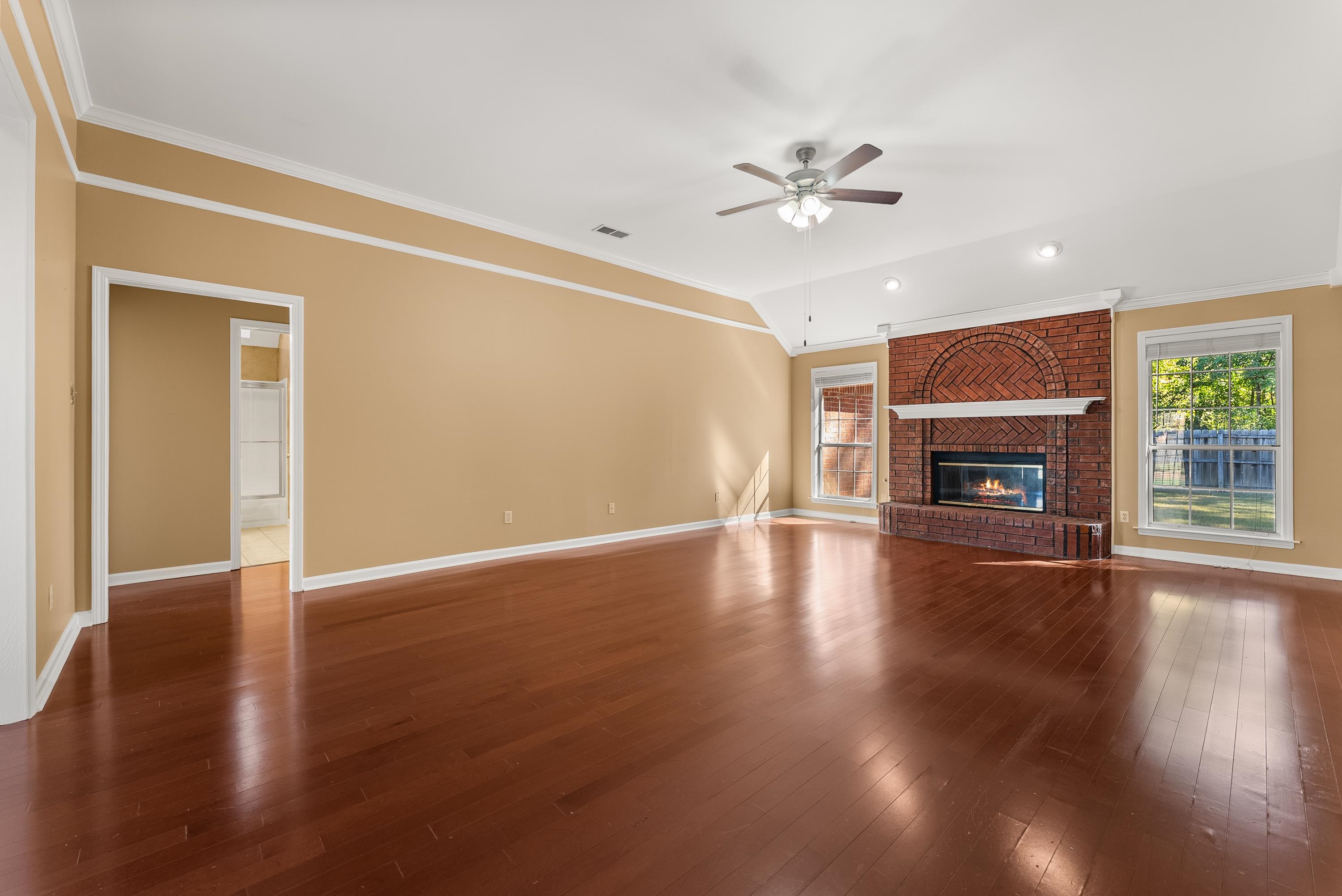 978 Sugar Lane Collierville, TN 38017 - Photo 2 of 14 a view of an empty room with wooden floor fireplace and a window