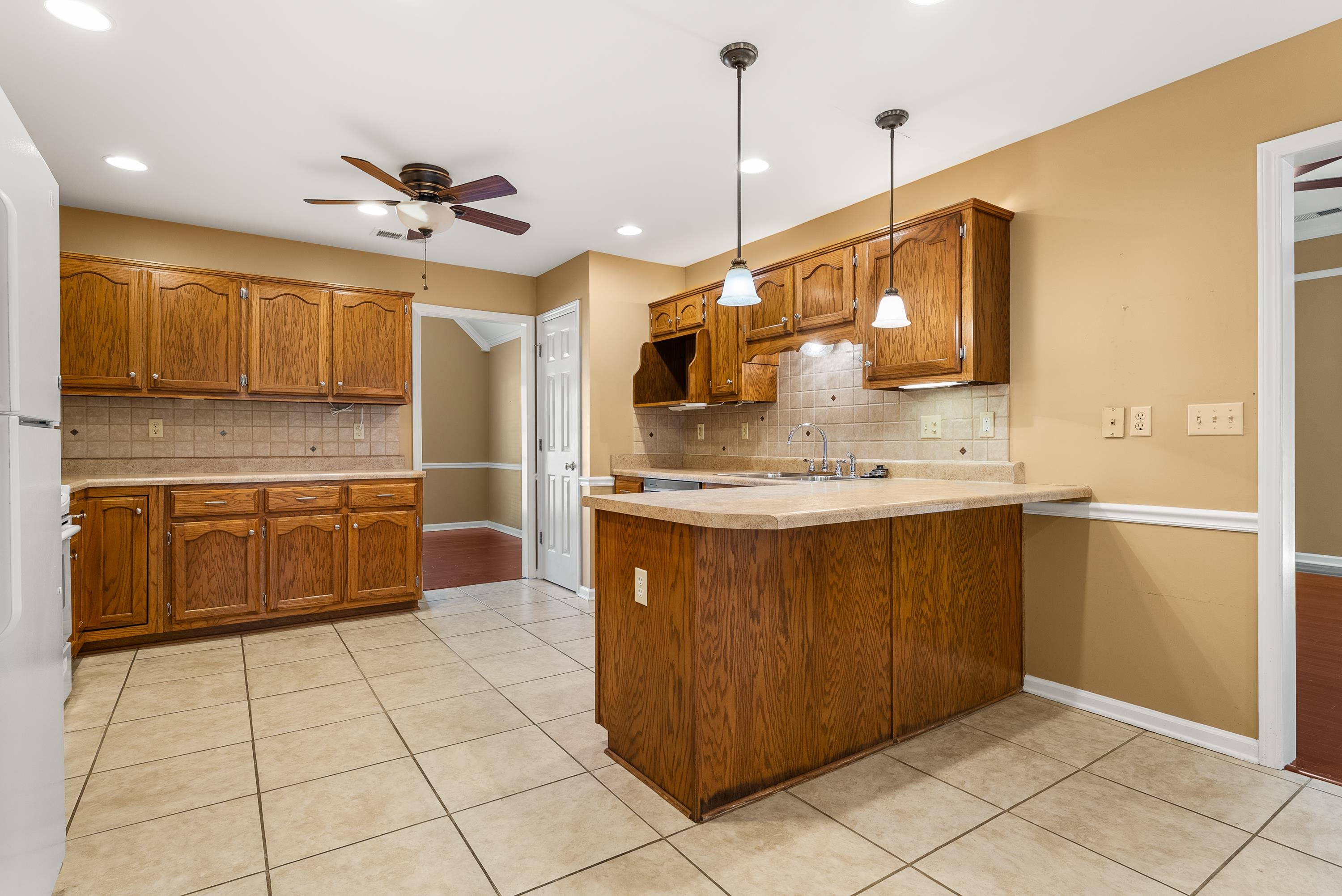 978 Sugar Lane Collierville, TN 38017 - Photo 4 of 14 a kitchen with kitchen island granite countertop a sink a counter top space cabinets and stainless steel appliances