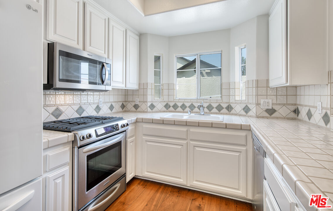 2333 Oak Street, Unit 2 Santa Monica, CA 90405 - Photo 15 of 30 a kitchen with granite countertop cabinets stainless steel appliances and wooden floor