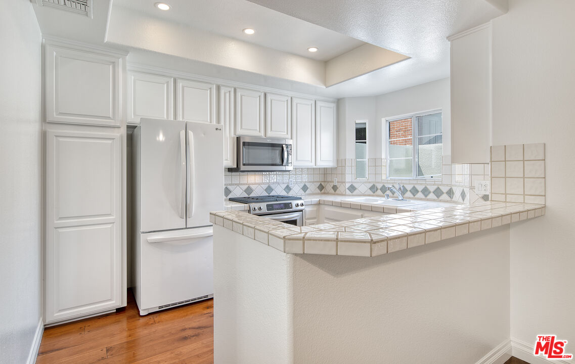 2333 Oak Street, Unit 2 Santa Monica, CA 90405 - Photo 16 of 30 a kitchen with kitchen island granite countertop a sink stove and refrigerator