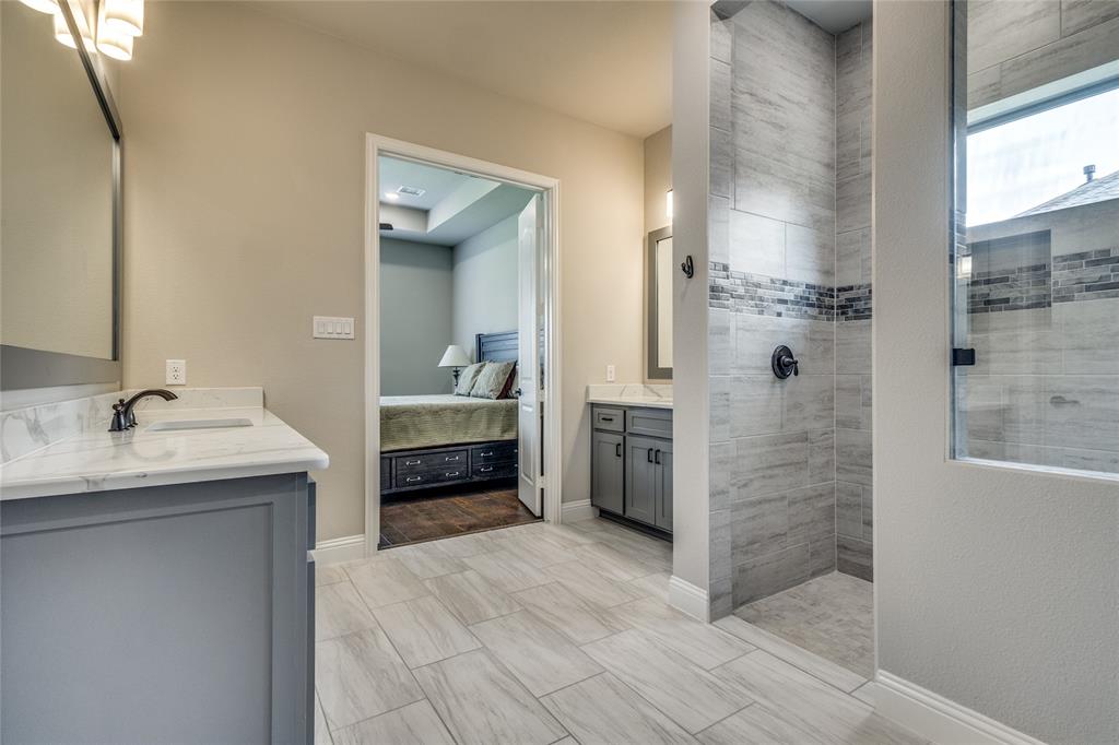 11112 Lacey Oak Ridge Flower Mound, TX 76226 - Photo 15 of 40 a bathroom with a granite countertop sink a mirror and shower