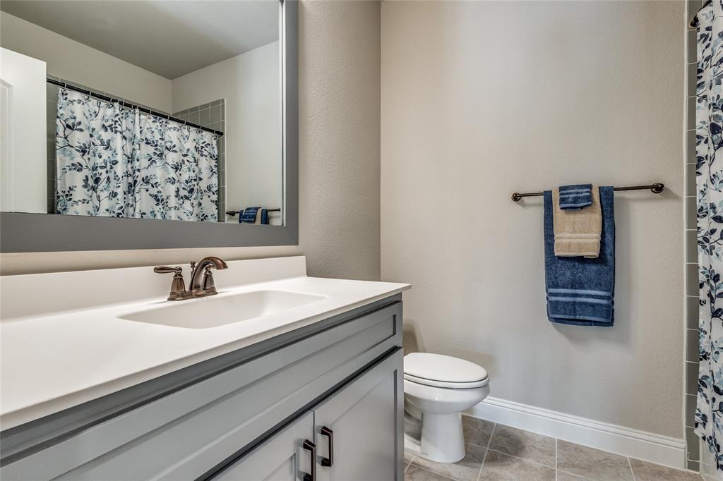 11112 Lacey Oak Ridge Flower Mound, TX 76226 - Photo 28 of 40 a bathroom with a toilet a sink and mirror