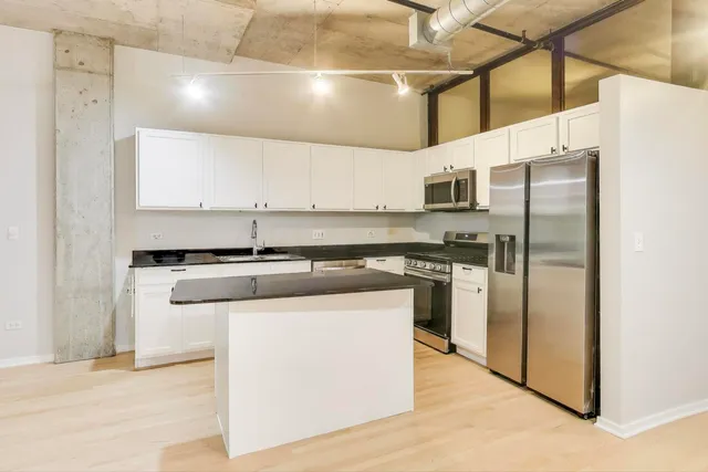 a kitchen with stainless steel appliances granite countertop a refrigerator and a stove