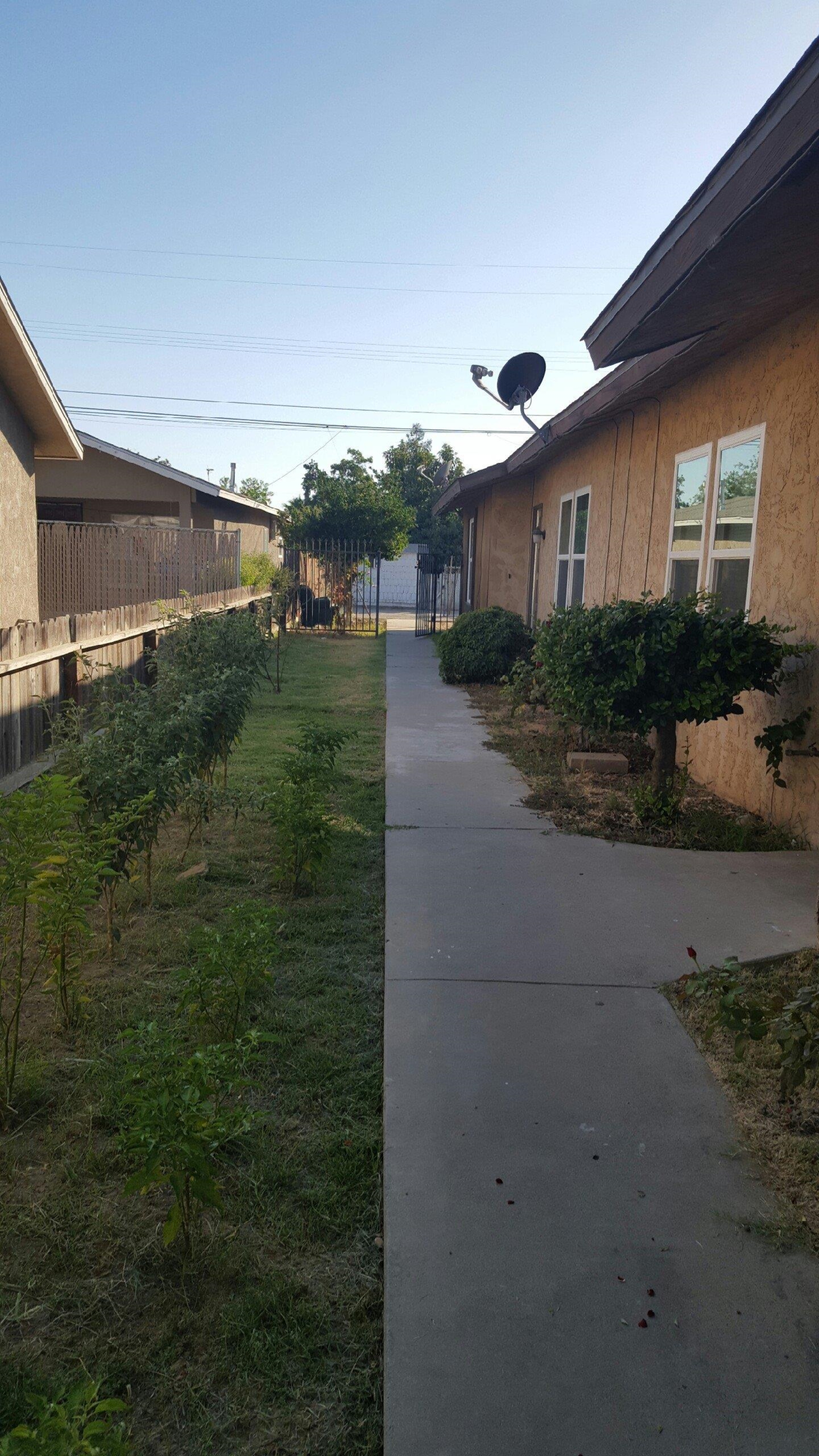 1235 C Street Reedley, CA 93654 - Photo 3 of 8 a front view of a house with garden