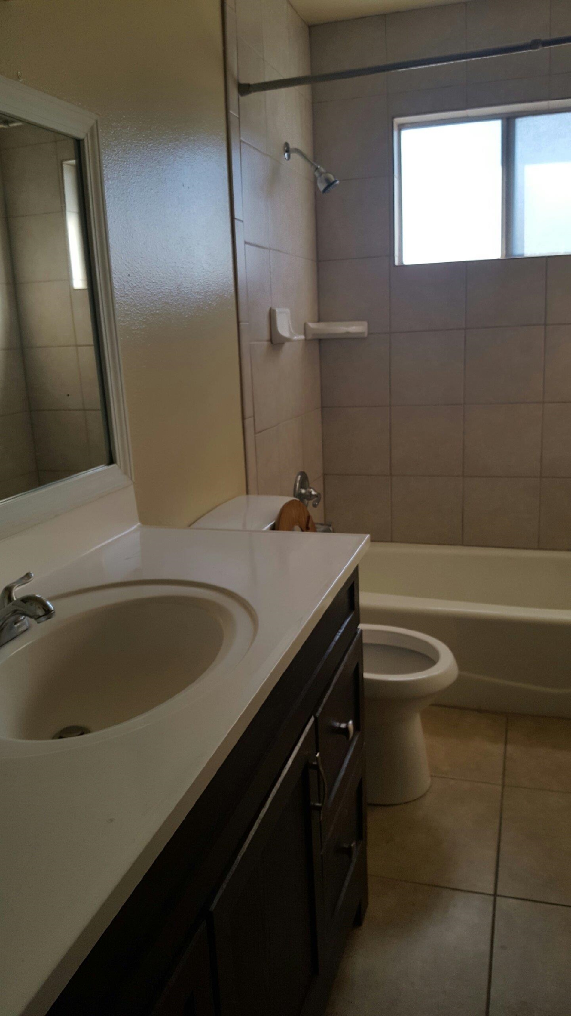 1235 C Street Reedley, CA 93654 - Photo 5 of 8 a bathroom with a granite countertop sink a toilet and bathtub