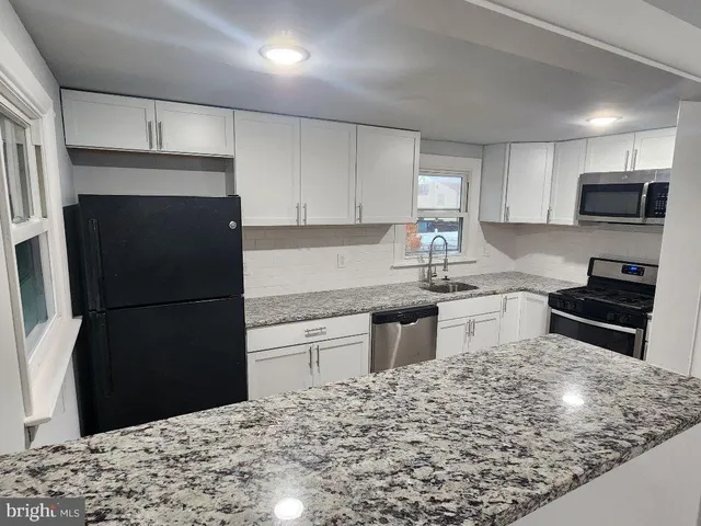a kitchen with a refrigerator and a stove top oven
