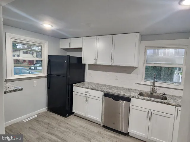 a kitchen with a refrigerator sink and cabinets