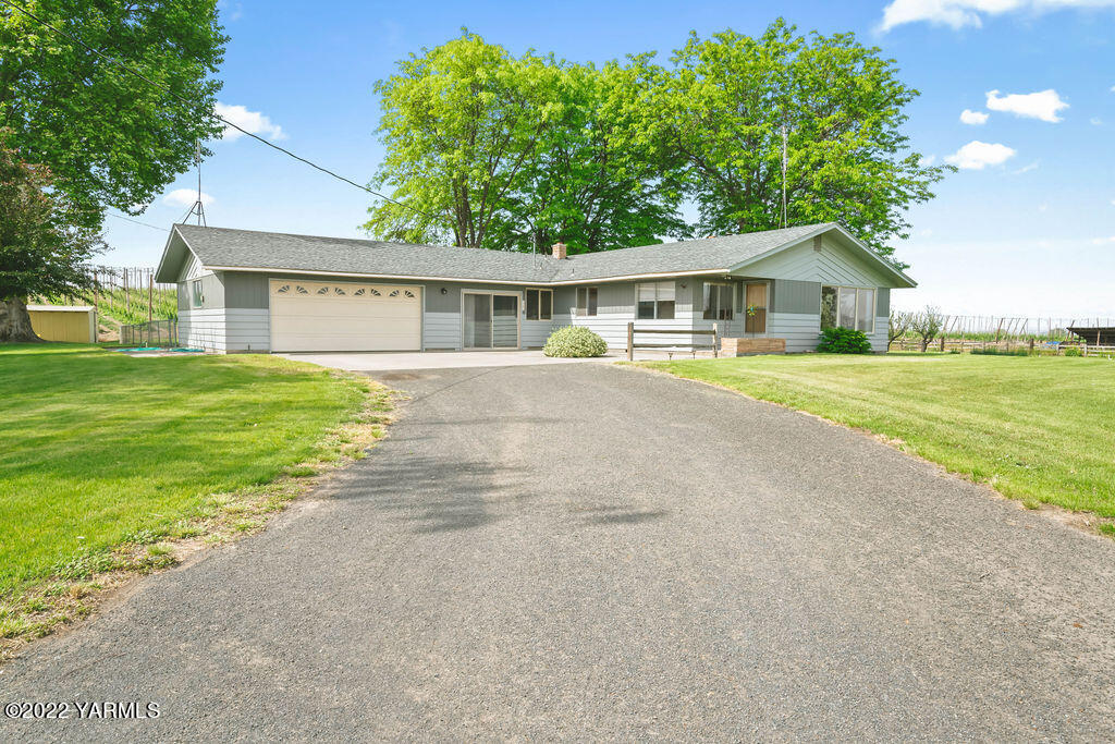 4180 Stover Road Sunnyside, WA 98944 - Photo 2 of 37 a front view of a house with a garden and trees
