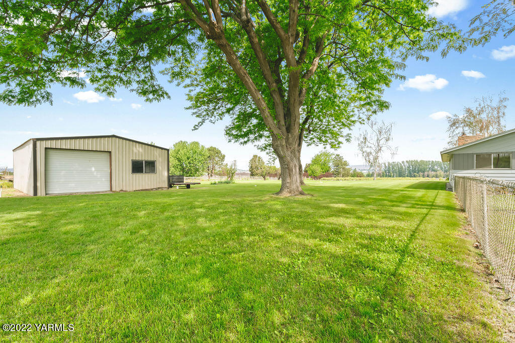 4180 Stover Road Sunnyside, WA 98944 - Photo 28 of 37 a backyard of a house with plants and large trees