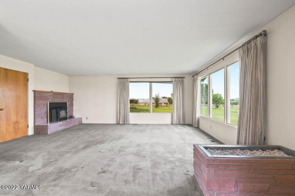 4180 Stover Road Sunnyside, WA 98944 - Photo 5 of 37 a view of an empty room with a fireplace and a window