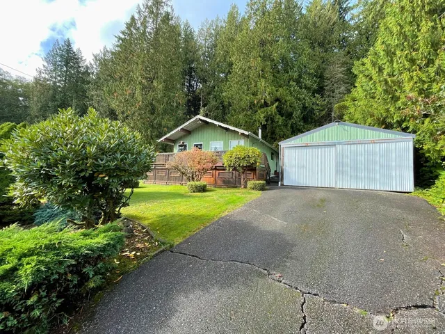 a view of swimming pool with lawn chairs and plants