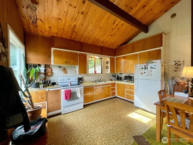 a kitchen with stainless steel appliances kitchen island granite countertop a table and chairs in it