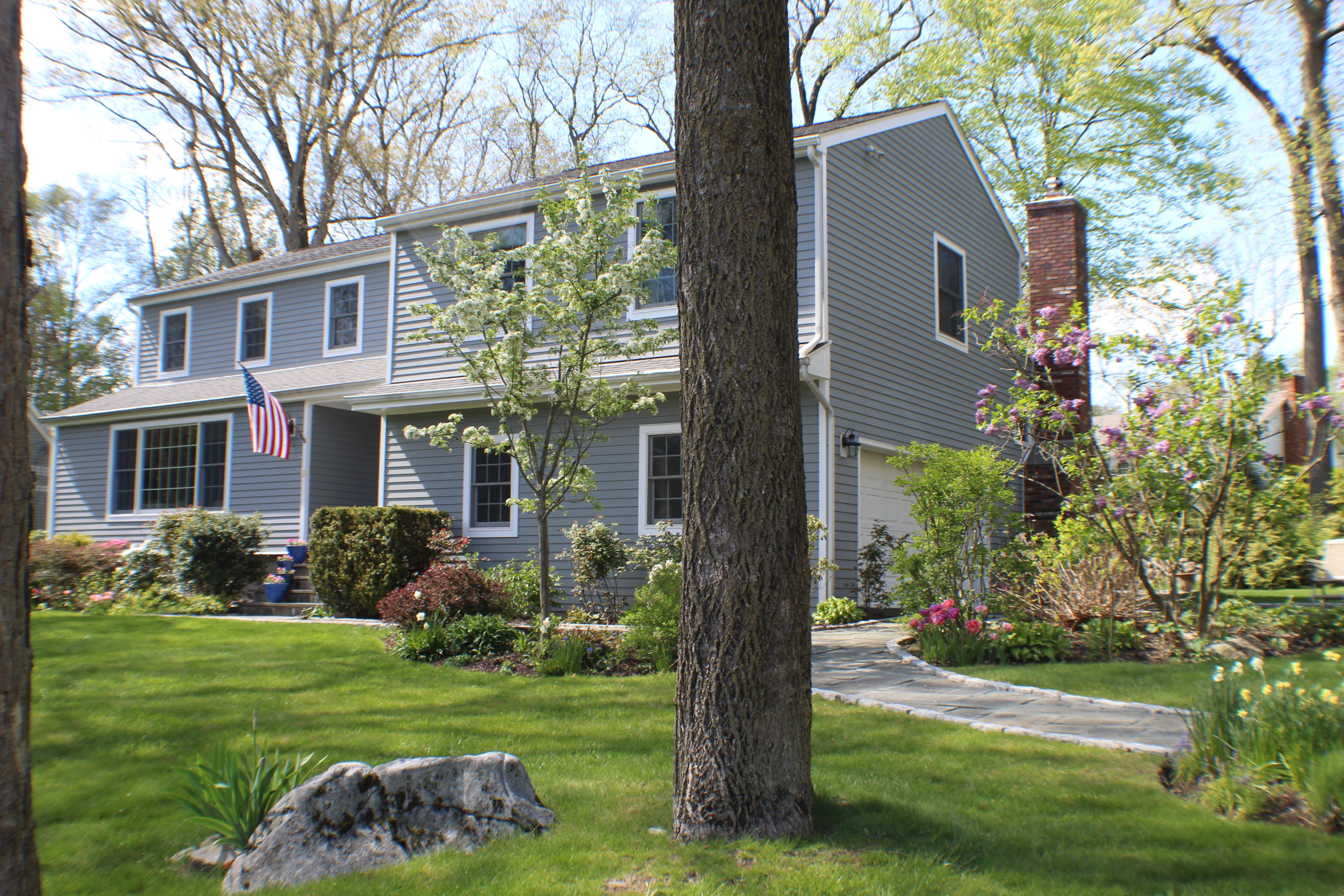 a front view of a house with a garden and plants