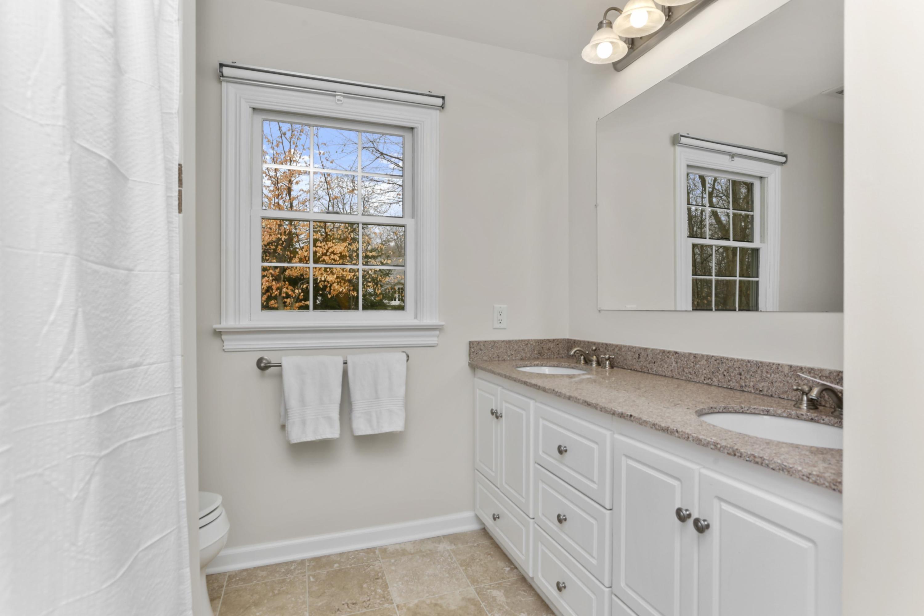 54 Country Club Road Darien, CT 06820 - Photo 29 of 40 a bathroom with a granite countertop sink a vanity and a shower