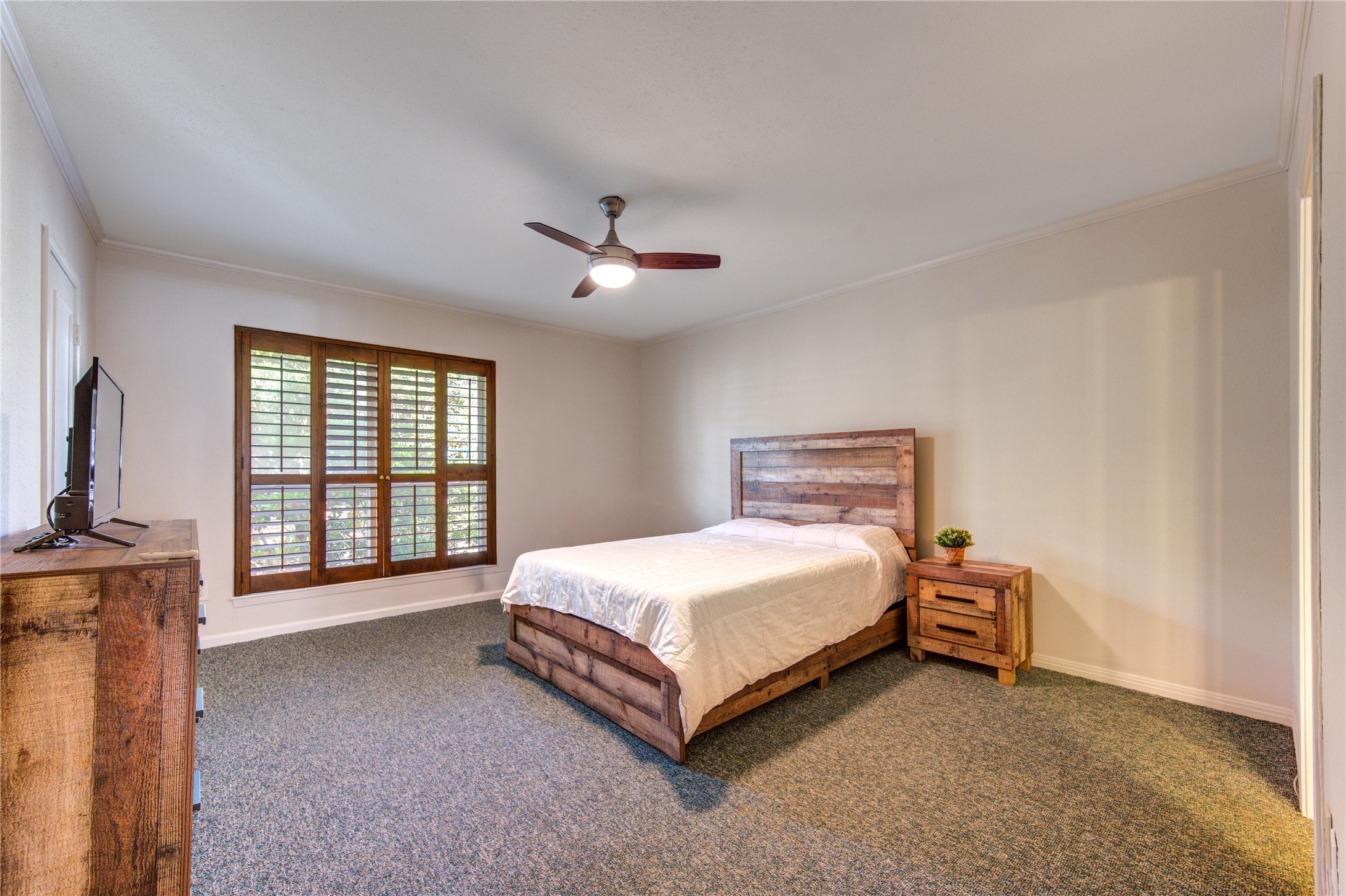 2232 South Piney Point Road, Unit 110 Houston, TX 77063 - Photo 13 of 21 Spacious secondary bedroom featuring plush carpeting, plantation shutters, and plenty of room for a king-sized bed and additional furnishings.