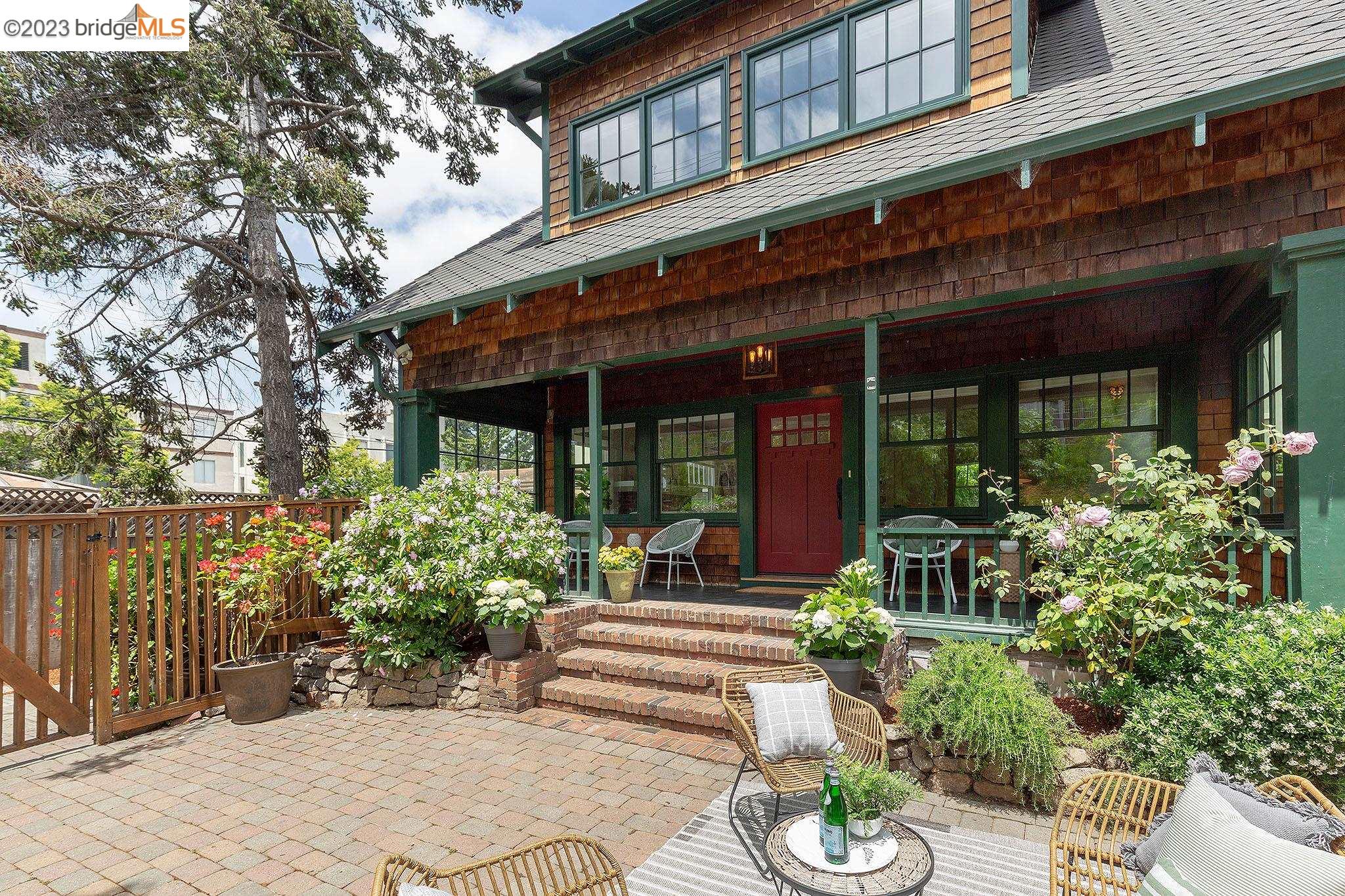 a view of a house with potted plants and a table and chairs