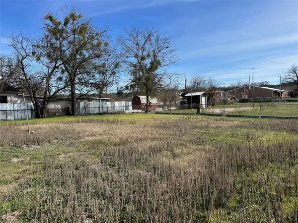 a view of a yard with a house in the background