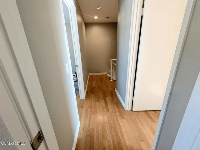 a view of a hallway with wooden floor and staircase