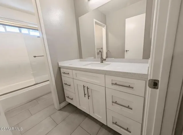 a bathroom with a double vanity sink and mirror