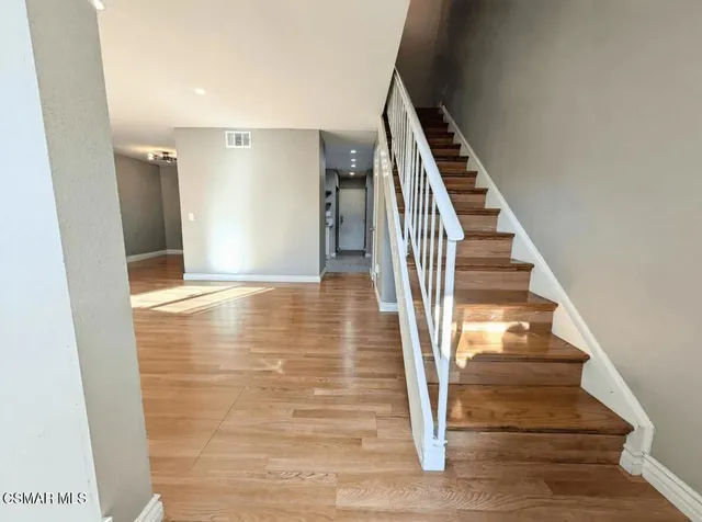 a view of a hallway with wooden floor and entryway