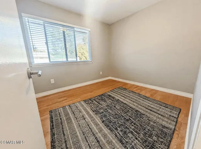 a view of a room with wooden floor and window