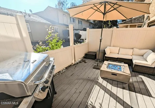 a balcony with wooden floor table and chairs