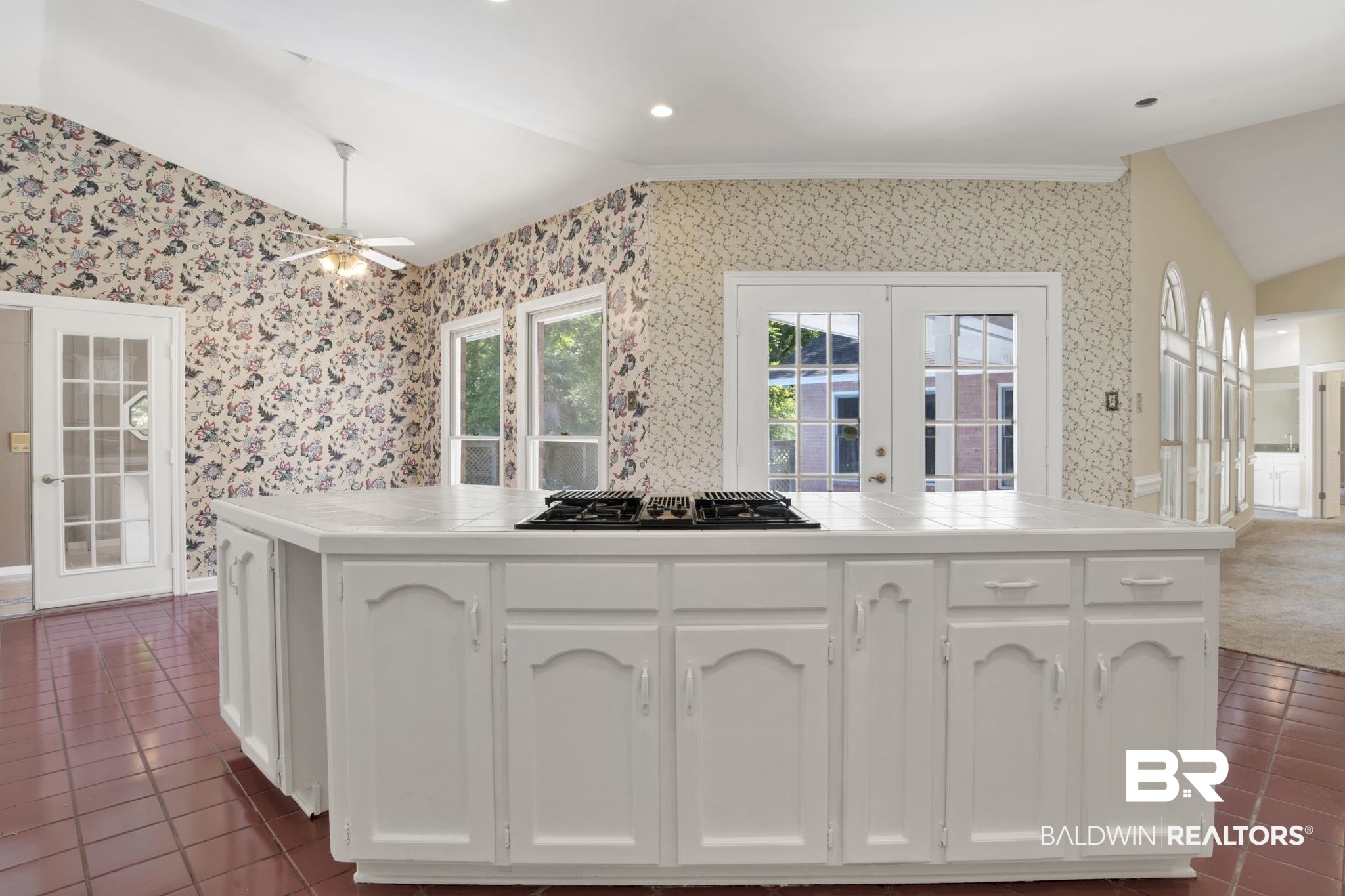 6805 Hunters Court Mobile, AL 36695 - Photo 16 of 37 Kitchen featuring lofted ceiling, wallpapered walls, tile counters, french doors, and black gas stovetop