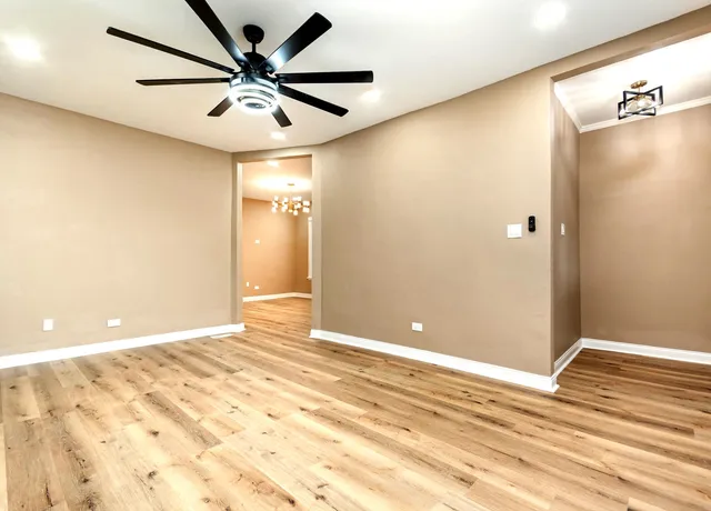 a view of a big room with wooden floor and a ceiling fan