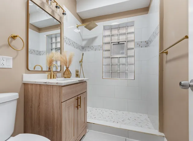 a bathroom with a sink a toilet and shower