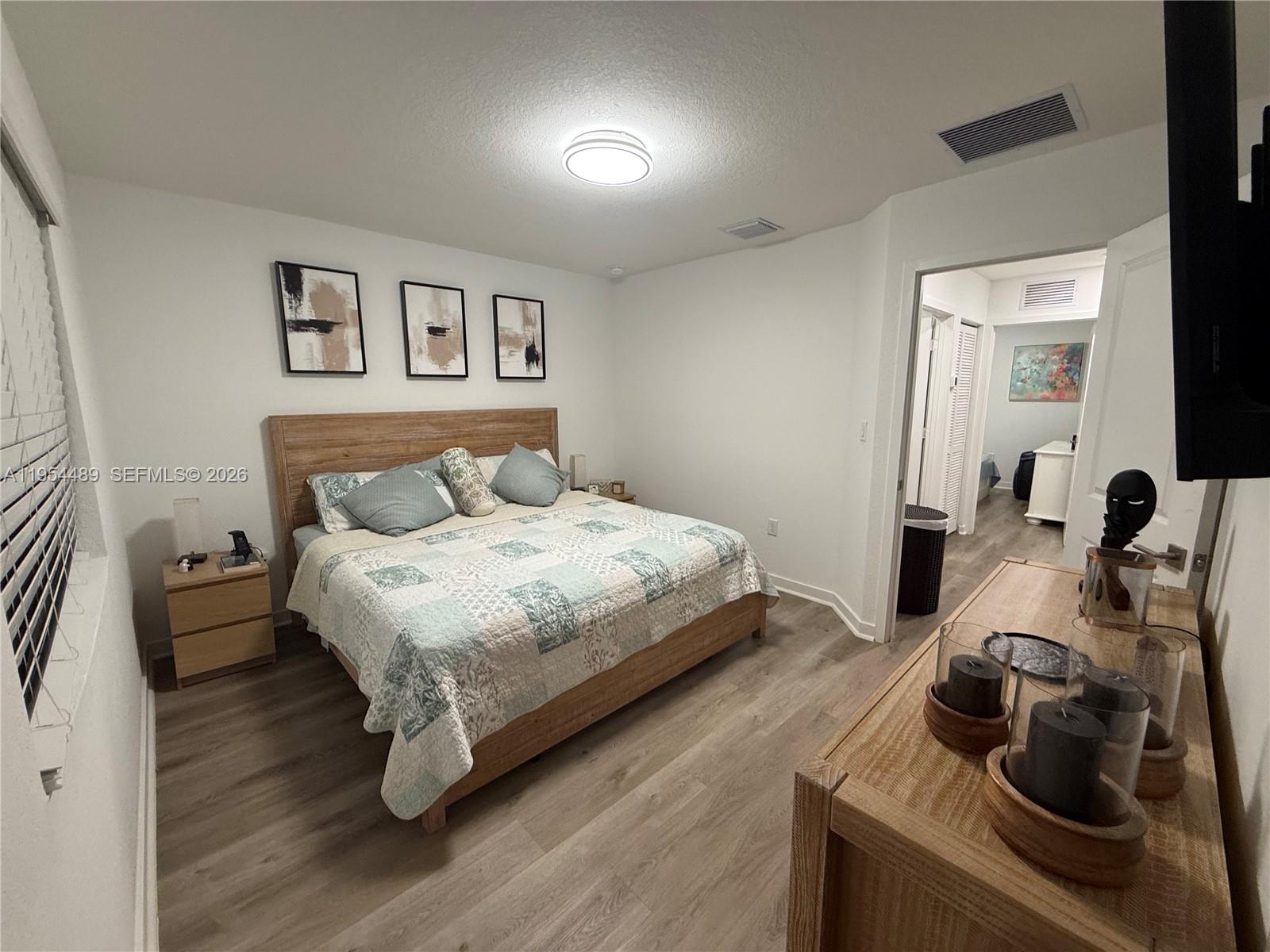 1043 Southeast 24th Avenue Homestead, FL 33035 - Photo 13 of 25 a bedroom with a bed and a wooden floor