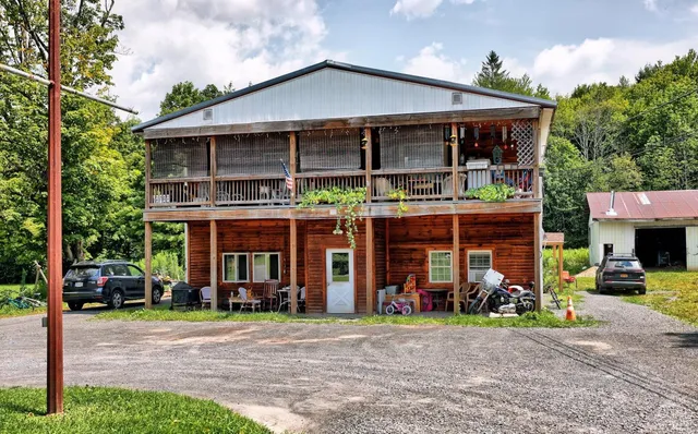 a view of a house with a patio and a yard