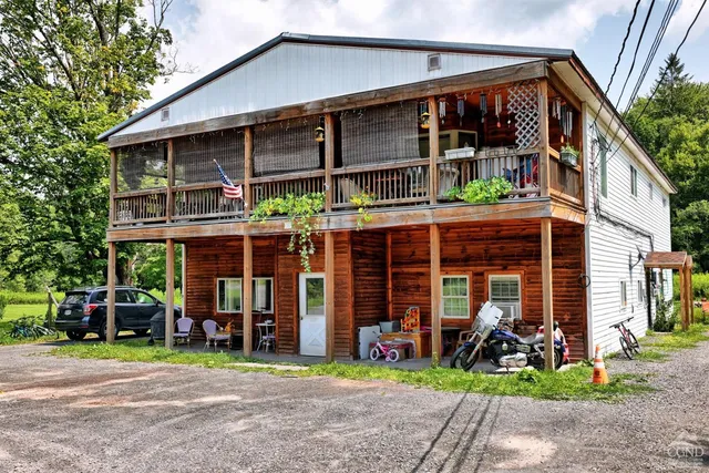 a view of a house with a porch and furniture