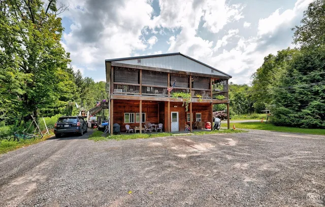a view of a house with a big yard and large trees