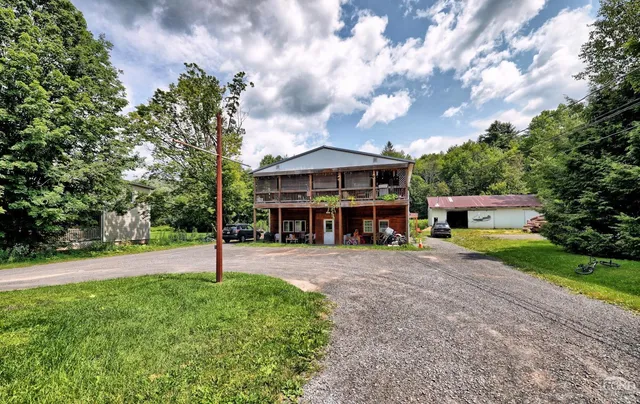 a view of a house with a yard and sitting area