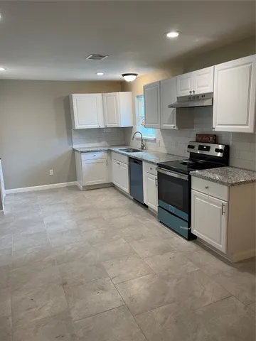 a kitchen with stainless steel appliances granite countertop a stove a sink and a refrigerator