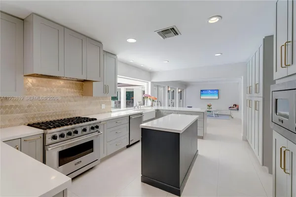 a kitchen with stainless steel appliances granite countertop a refrigerator and a dining table
