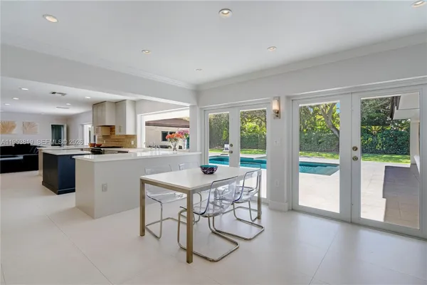 a dining room with furniture and large windows