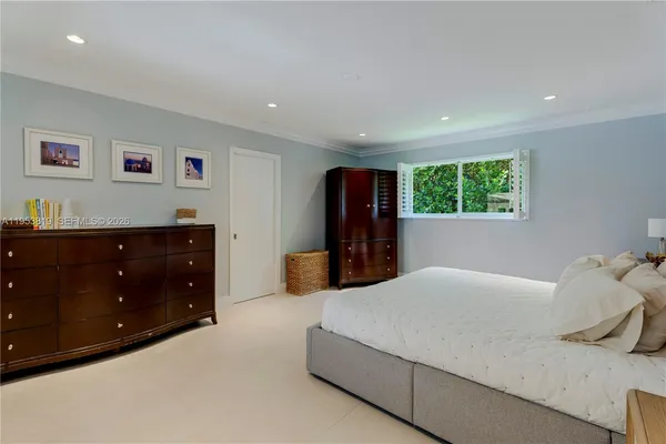 a spacious bedroom with a bed and a flat screen tv