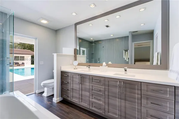 a bathroom with a bathtub a double vanity sink and mirrors