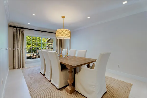 a view of a dining room with furniture a chandelier and wooden floor